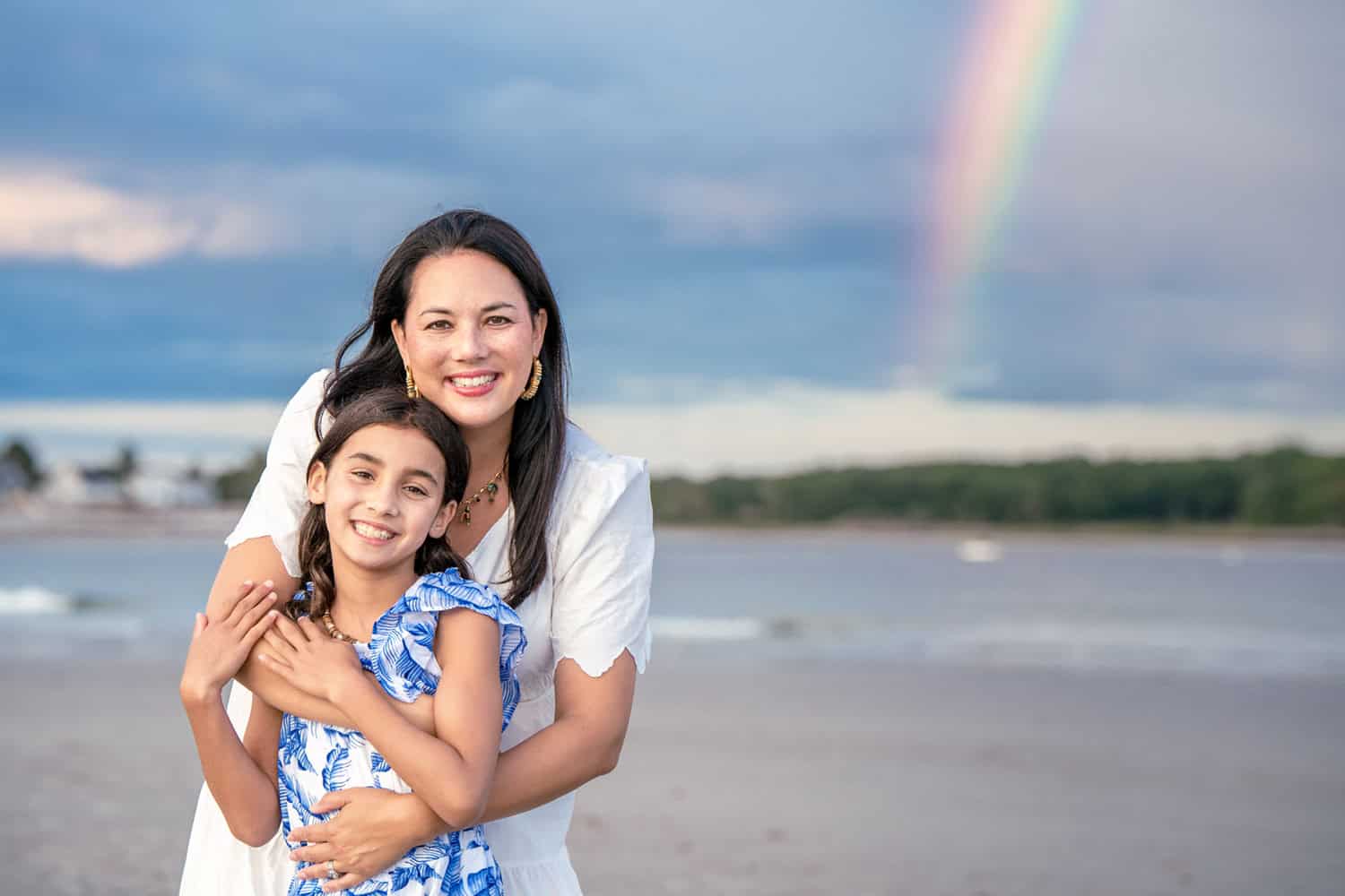 Family poses on Goose Rocks Beach for their Kennebunkport Family Portraits with a rainbow