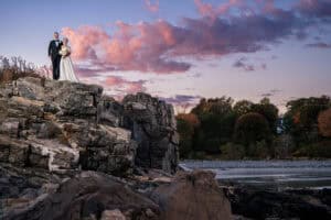 Couple stands on the cliffs at sunset for their Stage Neck Inn Wedding in York Maine