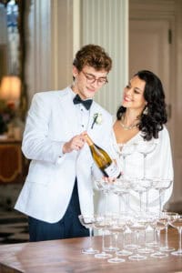 Bride and groom get ready to pour their champagne tower for a Newport Mansion Wedding