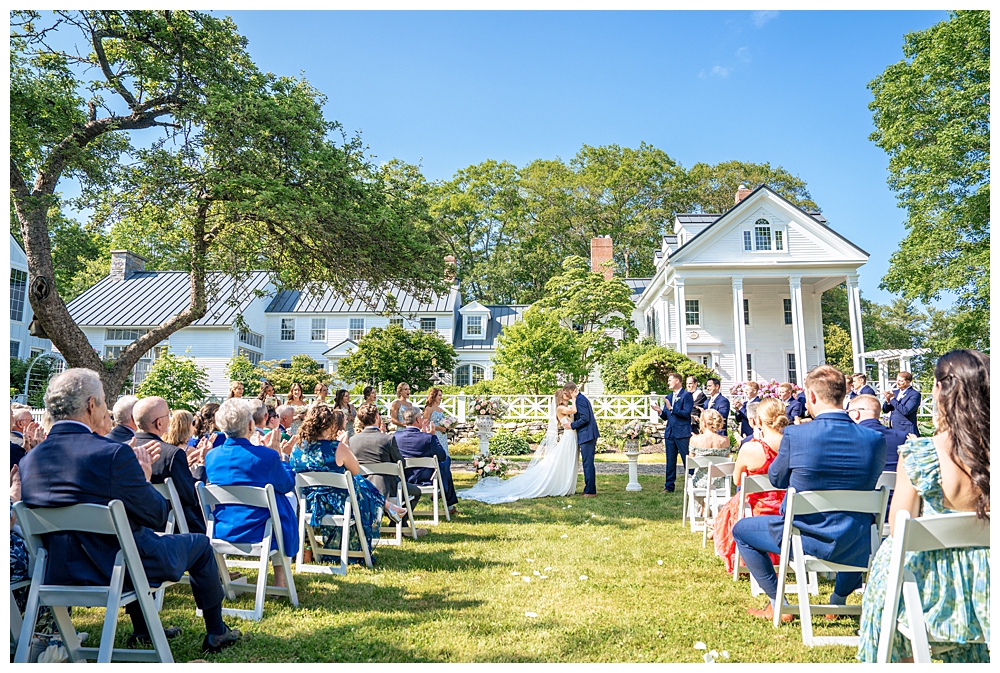 The Wiscasset White House wedding, Wiscasset Maine Wedding Photographers, couple is married on the lawn in front of the gorgeous building.