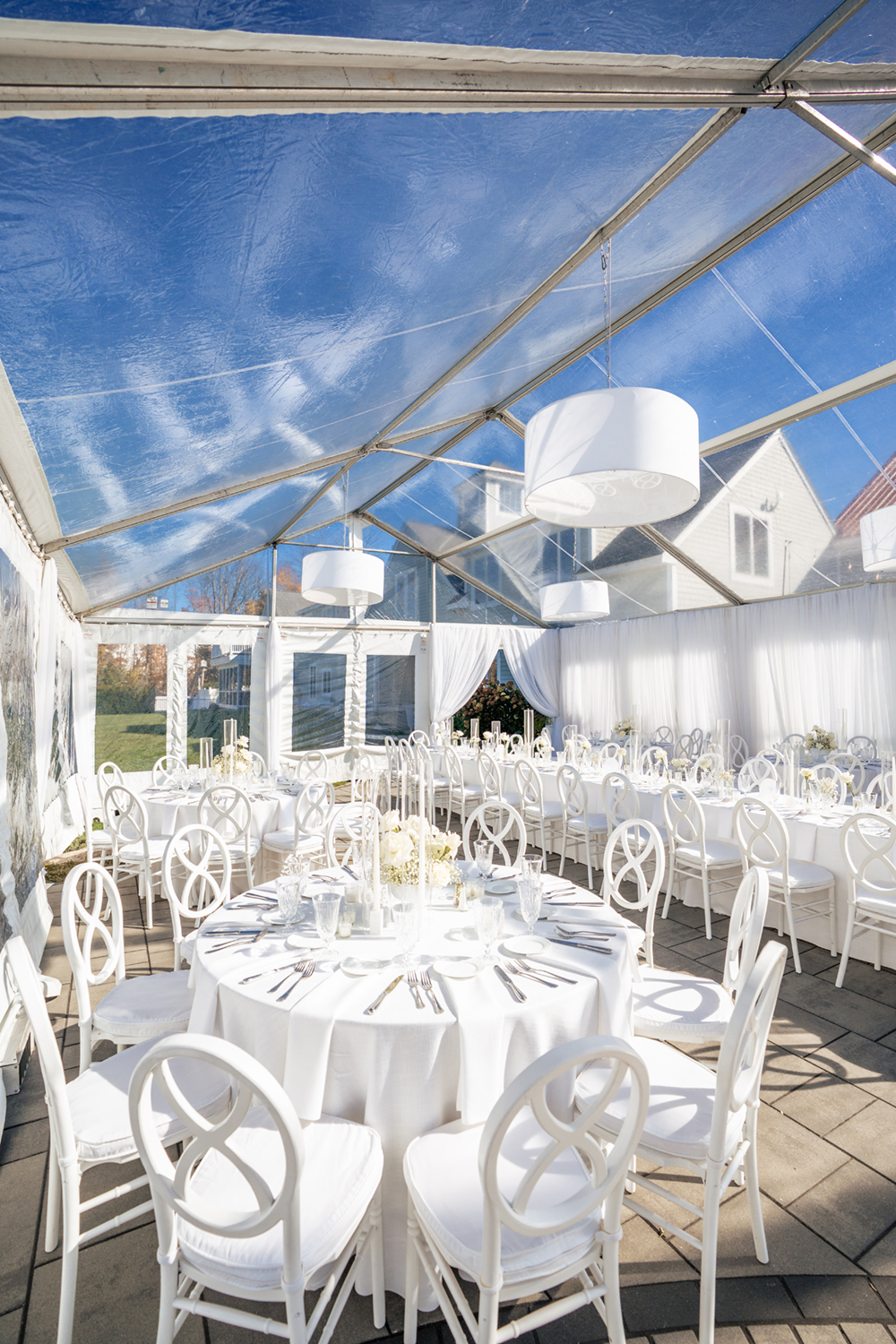 A white wedding theme for a clear top tent wedding. Captured by Maine Wedding Photographers, Two Adventurous Souls