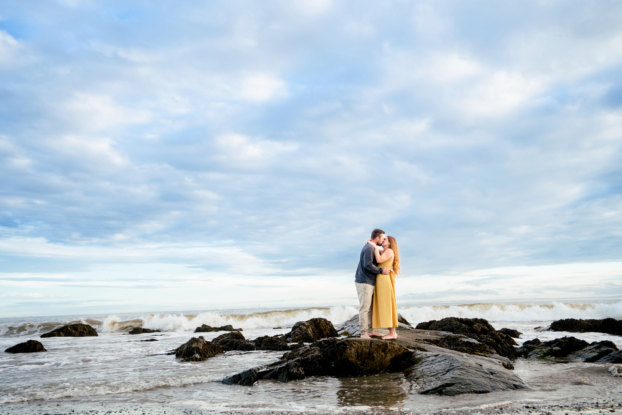 Kennebunkport Wedding Photographers capture a Kennebunkport Engagement on Colony Beach. A couple kisses on the rocks on Colony Beach