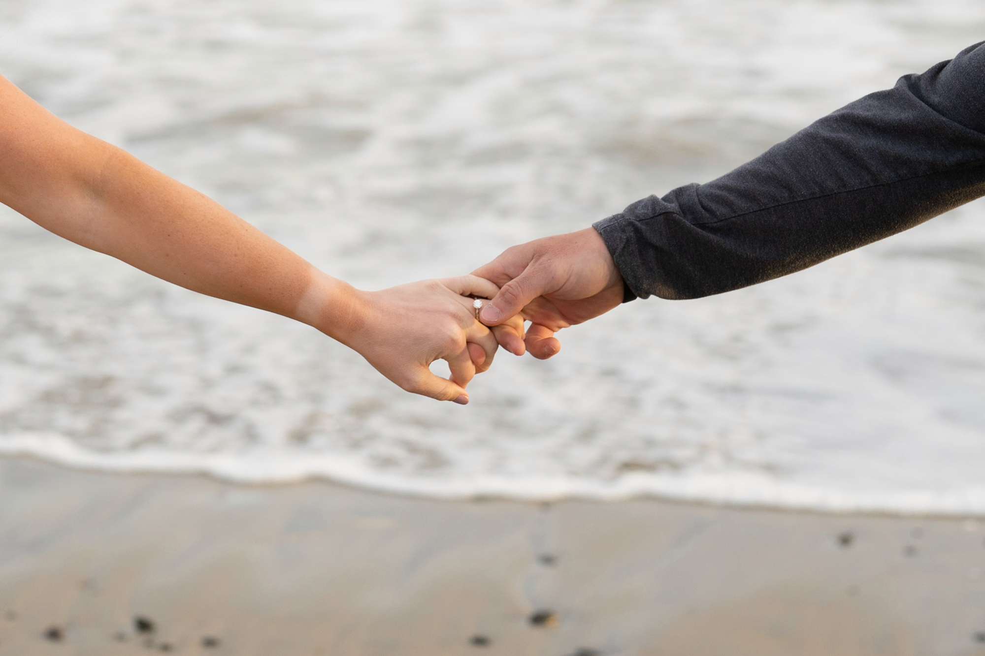 Kennebunkport Wedding Photographers capture a Kennebunkport Engagement on Colony Beach, a close up of holding hands with an engagement ring