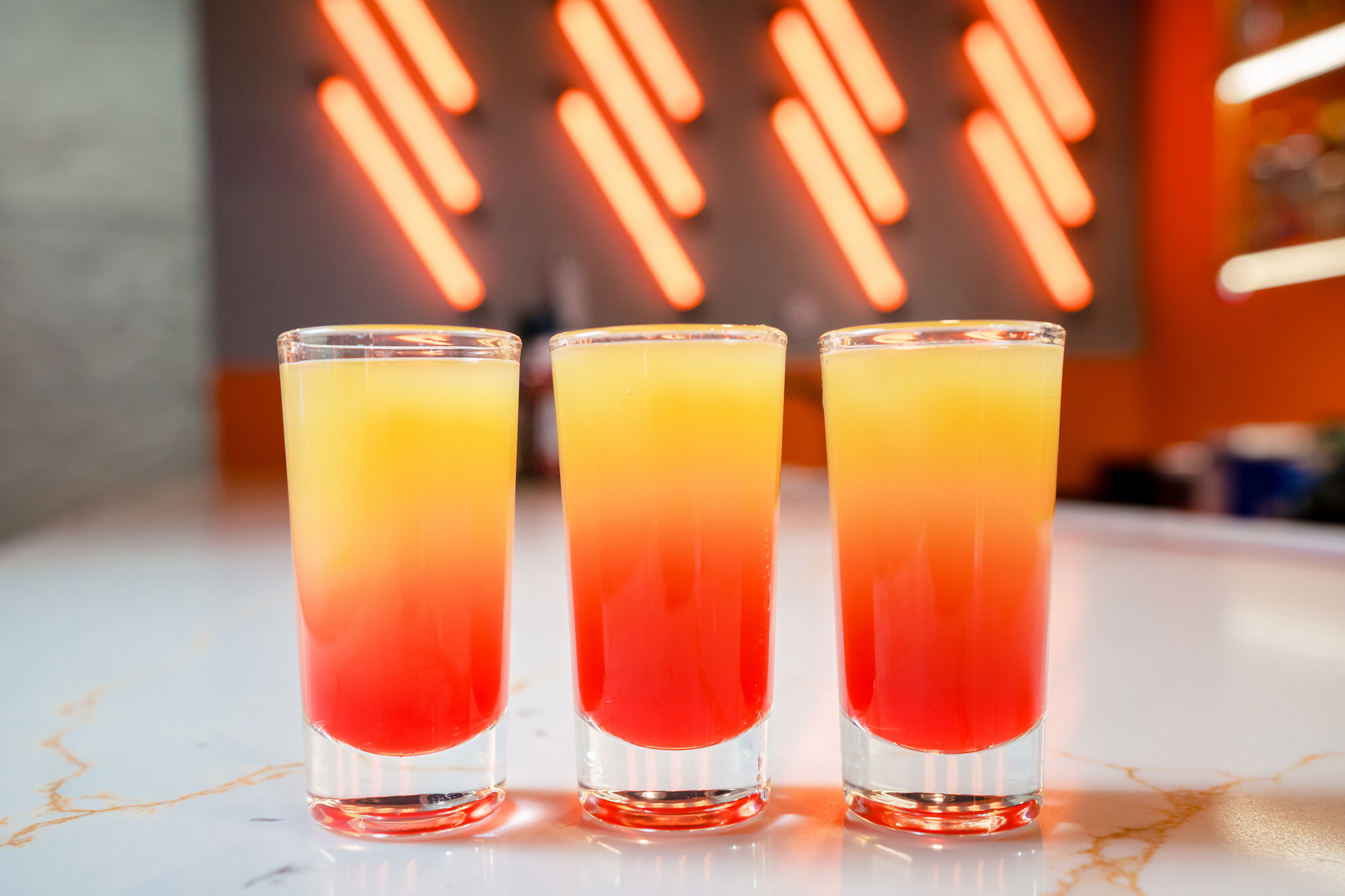 3 orange and red layered shots on a counter. Maine Food Photographer